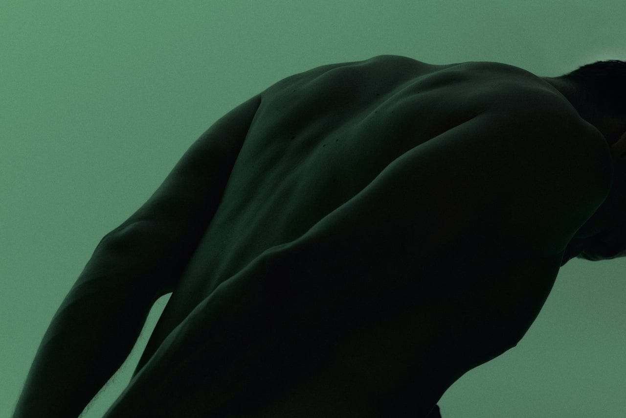 Dark silhouette of a person against a green background